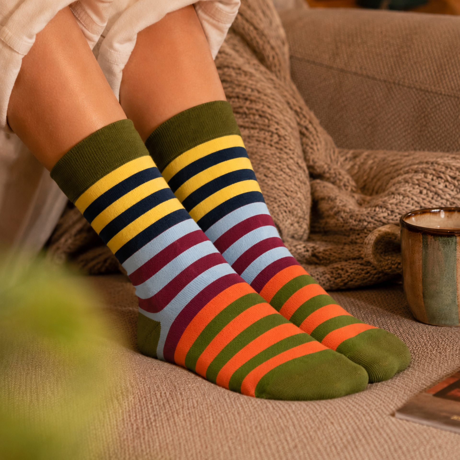 Chaussettes rayées au motif coloré de rayures horizontales. Couleurs : vert olive au bord-côte, talon et pointe ; jaune, bleu foncé, bleu clair, bordeaux et orange sur la tige. Douces, extensibles, tailles 41-46.