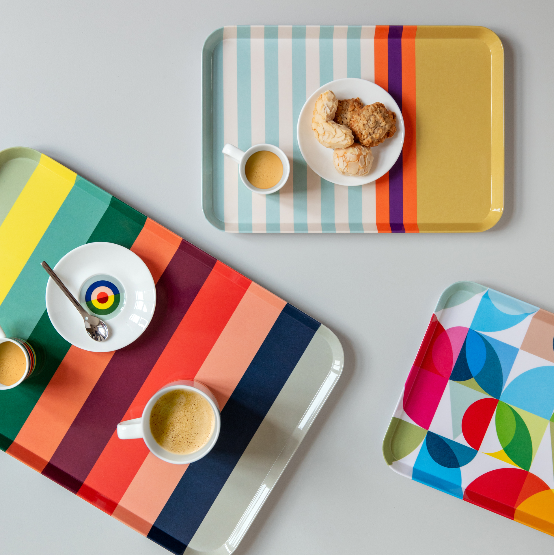 Rechteckiges, farbenfrohes Tablett mit abgerundeten Ecken. Es zeigt ein Streifenmuster in Gelb, Grün, Orange, Rot, Rosa und Blau.