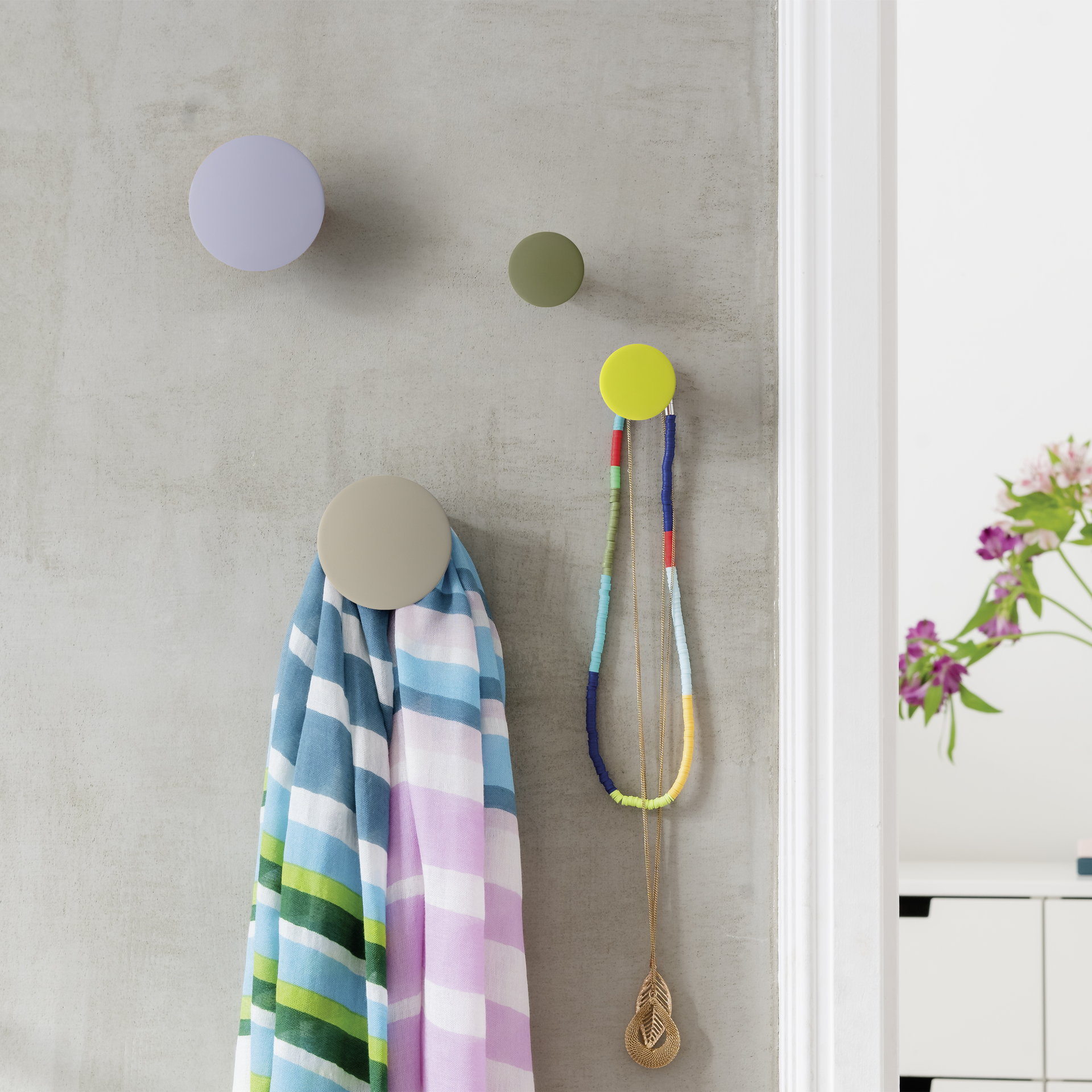 Vier Wandhaken des 'Tulip' Sets: Zwei kleine in Olivgrün und Gelb, zwei größere in Grau und Beige.