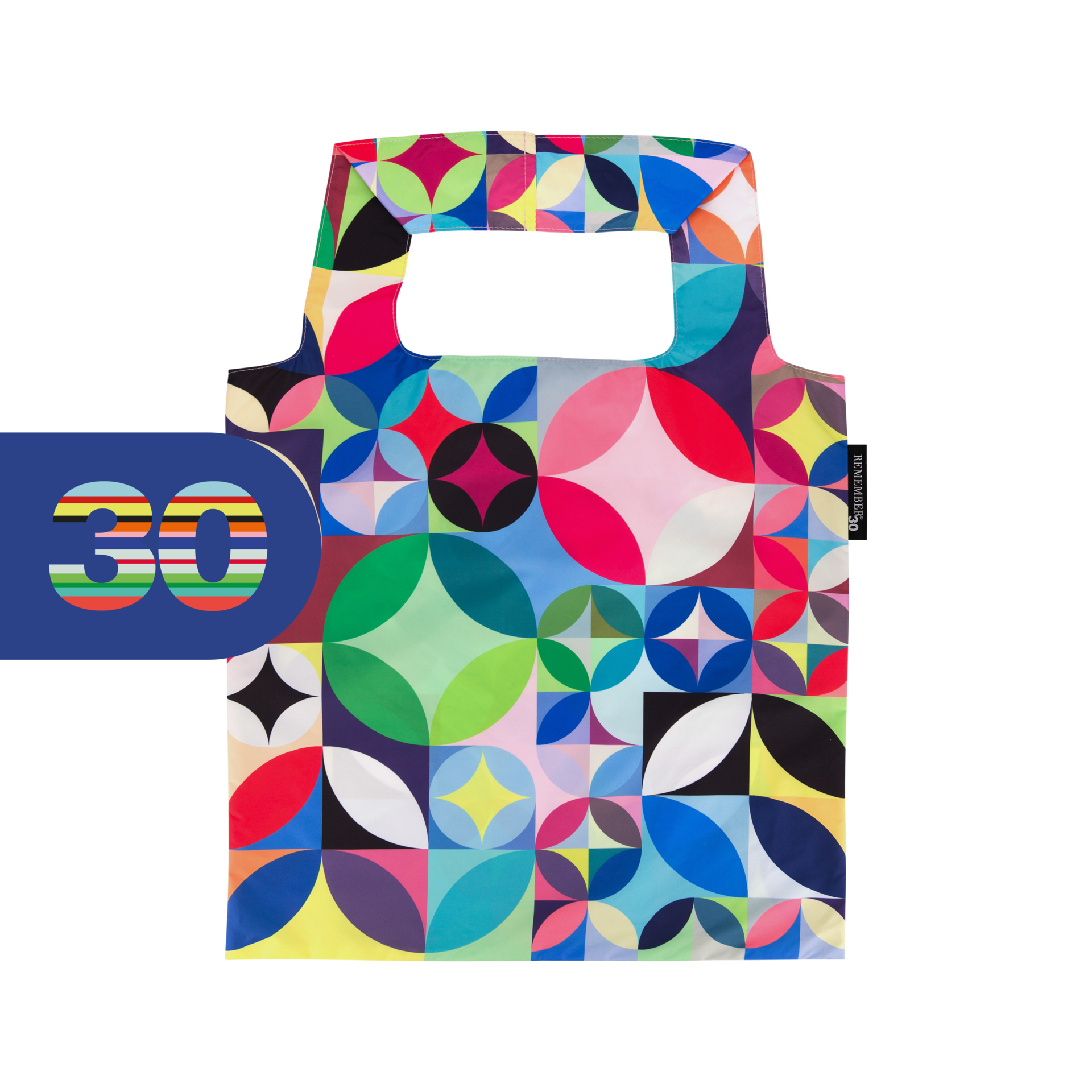Sac de transport pliable aux couleurs vives, orné d’un motif géométrique « Rosetta » de cercles et quarts de cercle en tons rouge, bleu, vert, jaune, rose, noir et blanc. Deux poignées sur fond blanc et banderole bleue « 30 ».