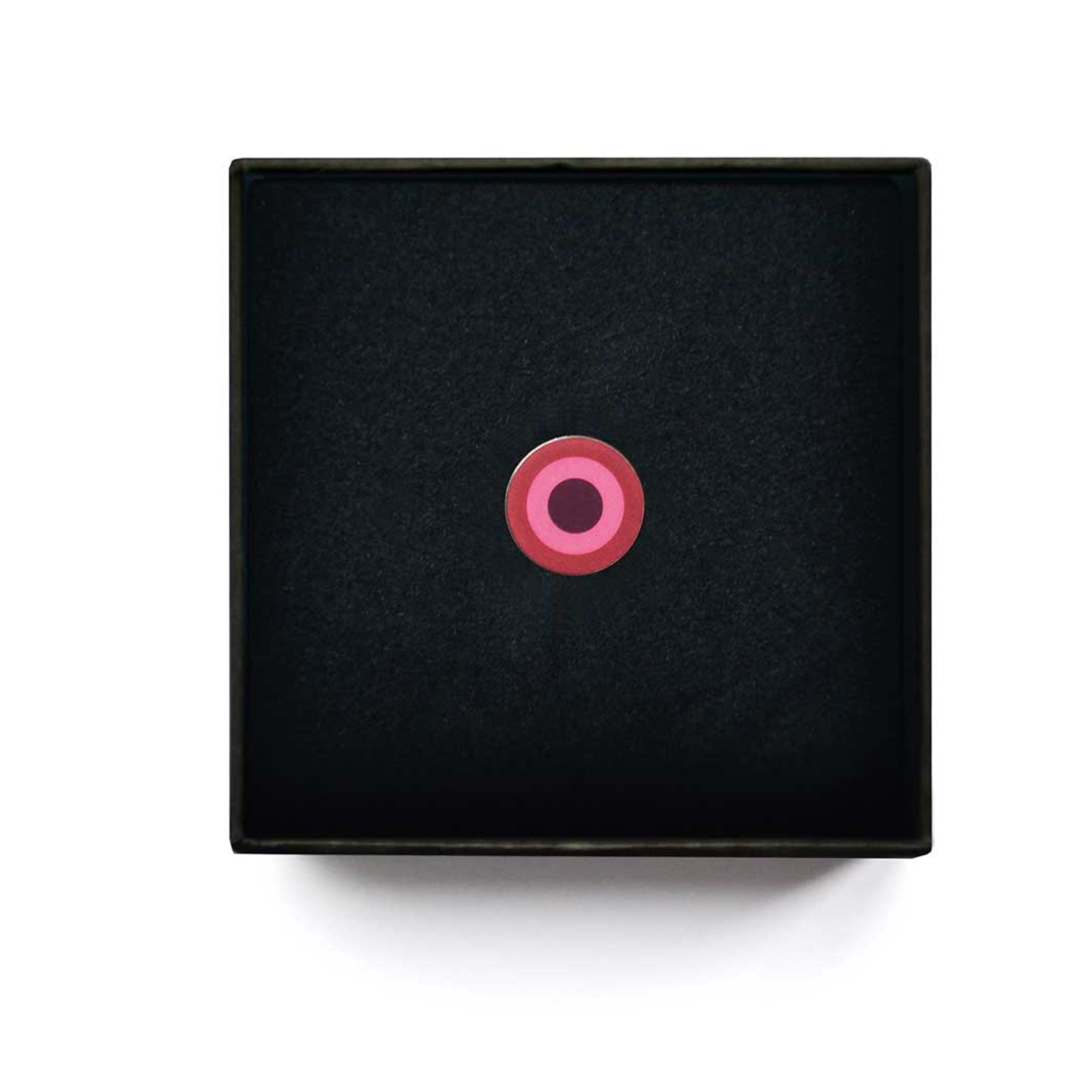 Ciondolo di gioielleria nero con cerchi concentrici rosa al centro.