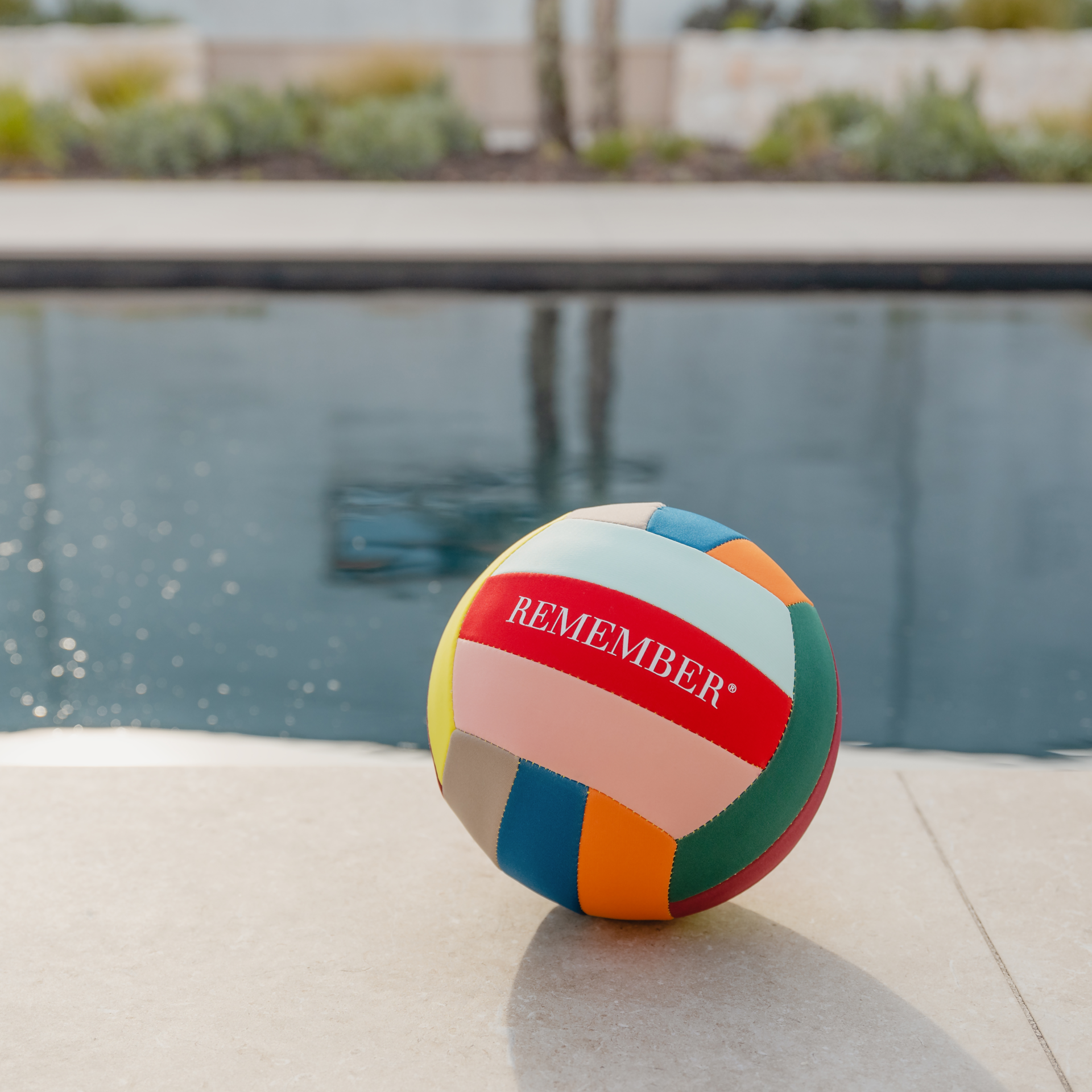 Ein runder Freizeit-Ball in Volleyball-Größe, zusammengesetzt aus bunten Segmenten, mit dem Schriftzug "REMEMBER" auf einem roten Segment.