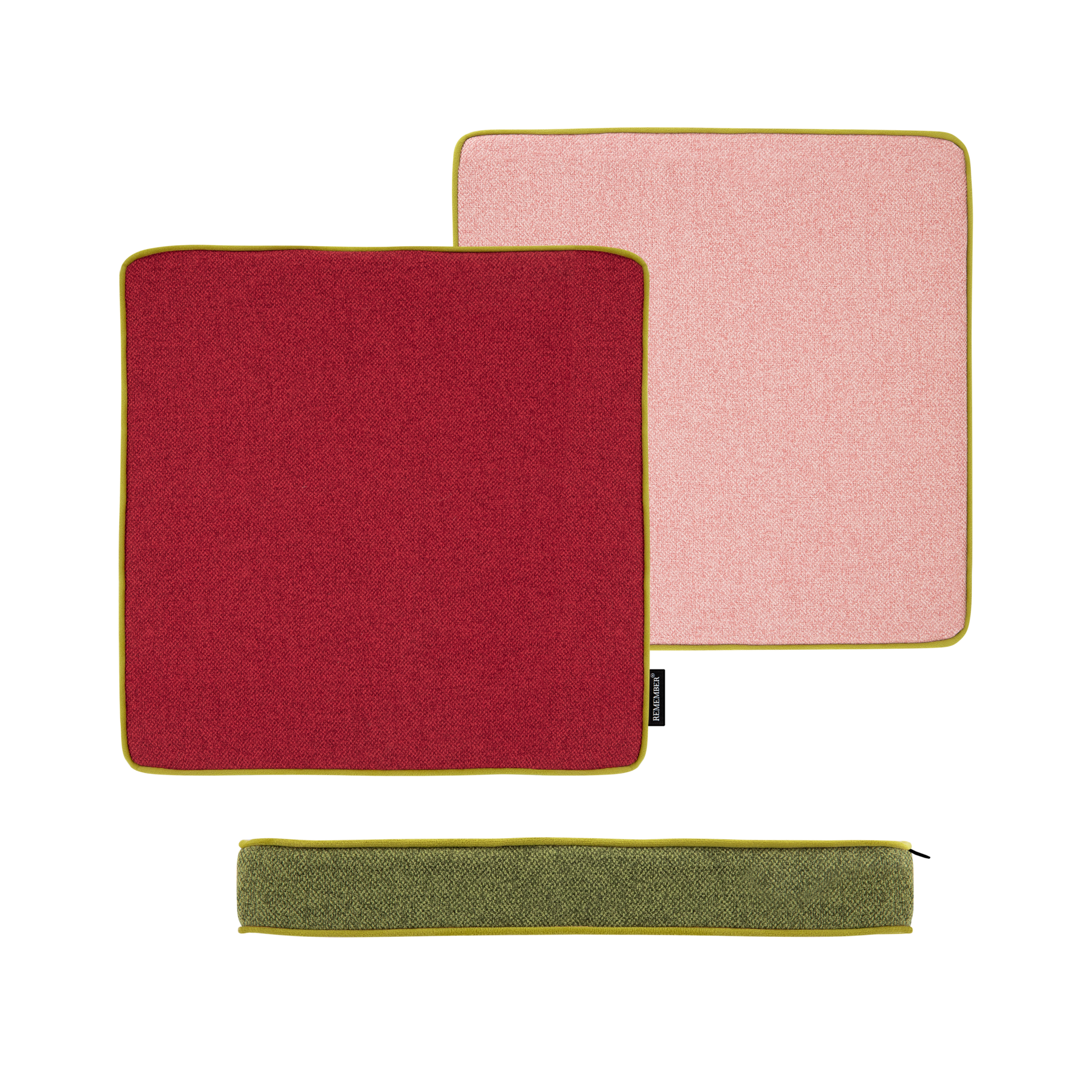 Zwei quadratische Sitzkissen in Cranberry-Rot und Rosa, umrandet mit grünem Samtband. Unten ein schmales Kissen mit Reißverschluss, ebenfalls in Grün.