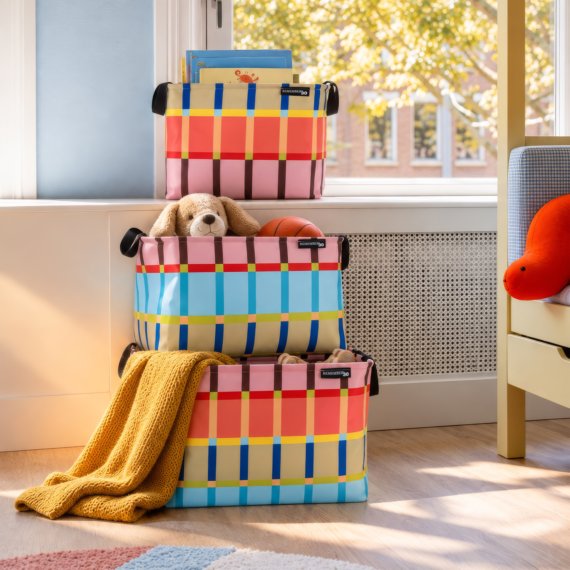 Trois paniers de rangement colorés empilés sur fond blanc. Paniers Kaido à carreaux éclatants (rose, rouge, bleu, jaune, vert, beige), avec poignées noires et étiquette « REMEMBER30 », parfaits pour le rangement.
