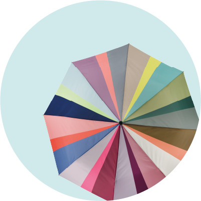 Von oben geöffneter Regenschirm mit vielen Segmenten in Pastell- und Erdtönen: Hellblau, Mintgrün, Dunkelblau, Koralle, Rosa, Grau, Lila, Beige, Gelb und Dunkelgrün, radial um die schwarze Achse.