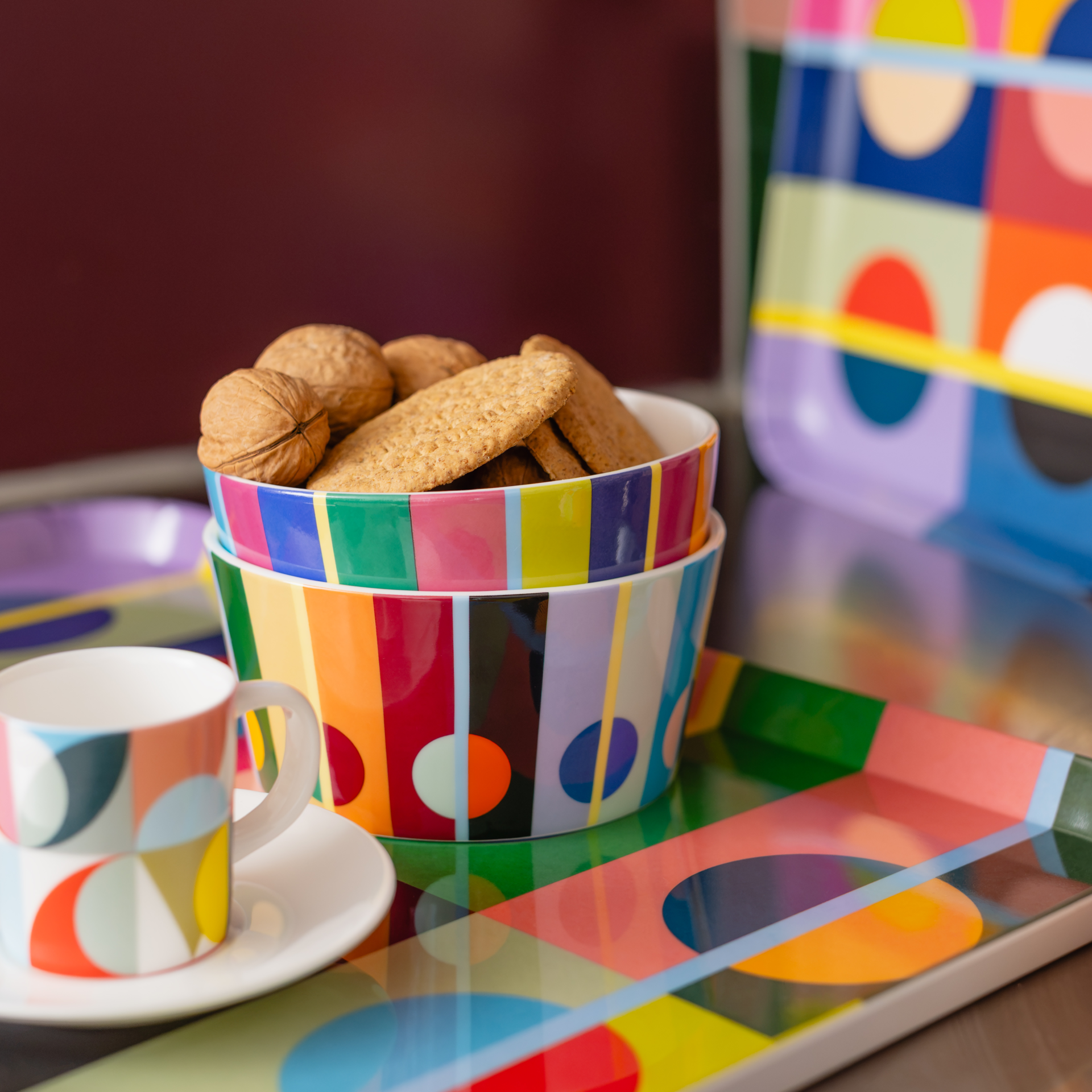 Bunte Müslischale Orb mit Streifenmuster in Pink, Hellgrün, Orange und Beige. Darauf verspielte Kreise und Halbkreise in Magenta, Gelb, Grün und Schwarz. Glatte, weiße Innenseite, farbenfroh.