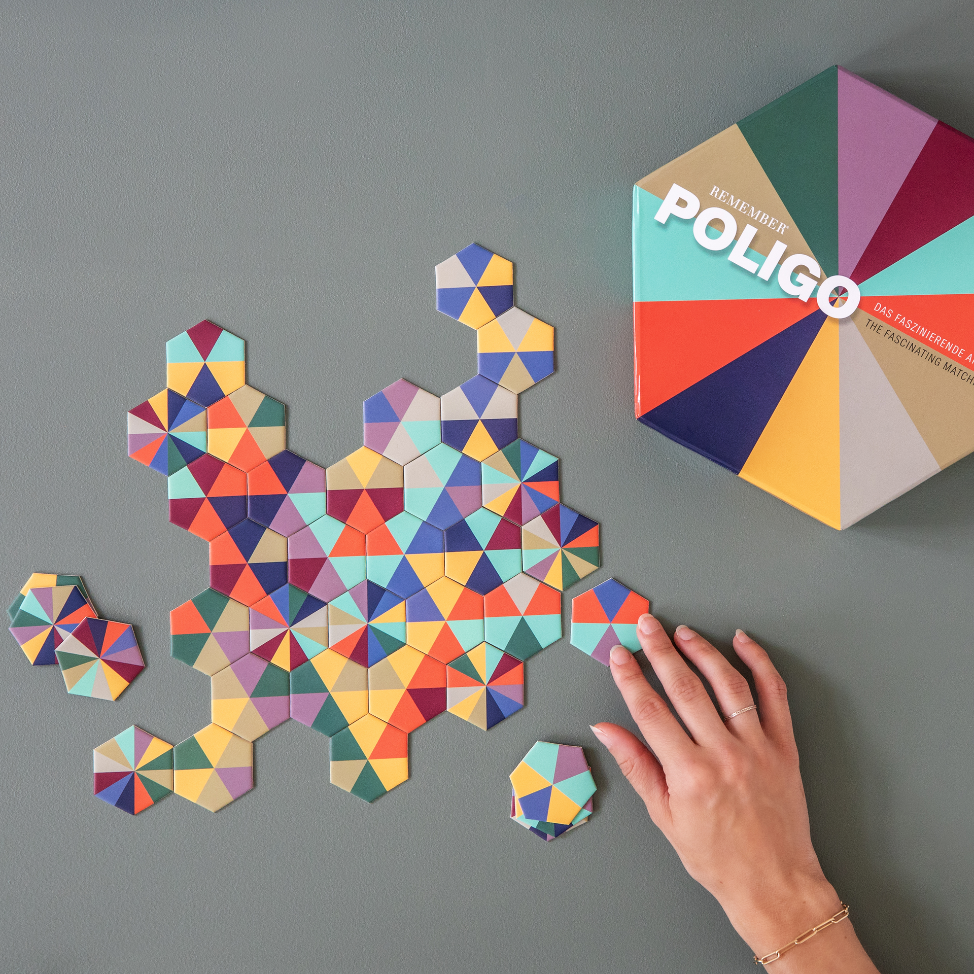 Sechseckige Spielschachtel von "Poligo" mit Farbrad. Das Spiel ist ein fesselndes Anlegespiel. Verschiedene Farben sind auf der Schachtel abgebildet.