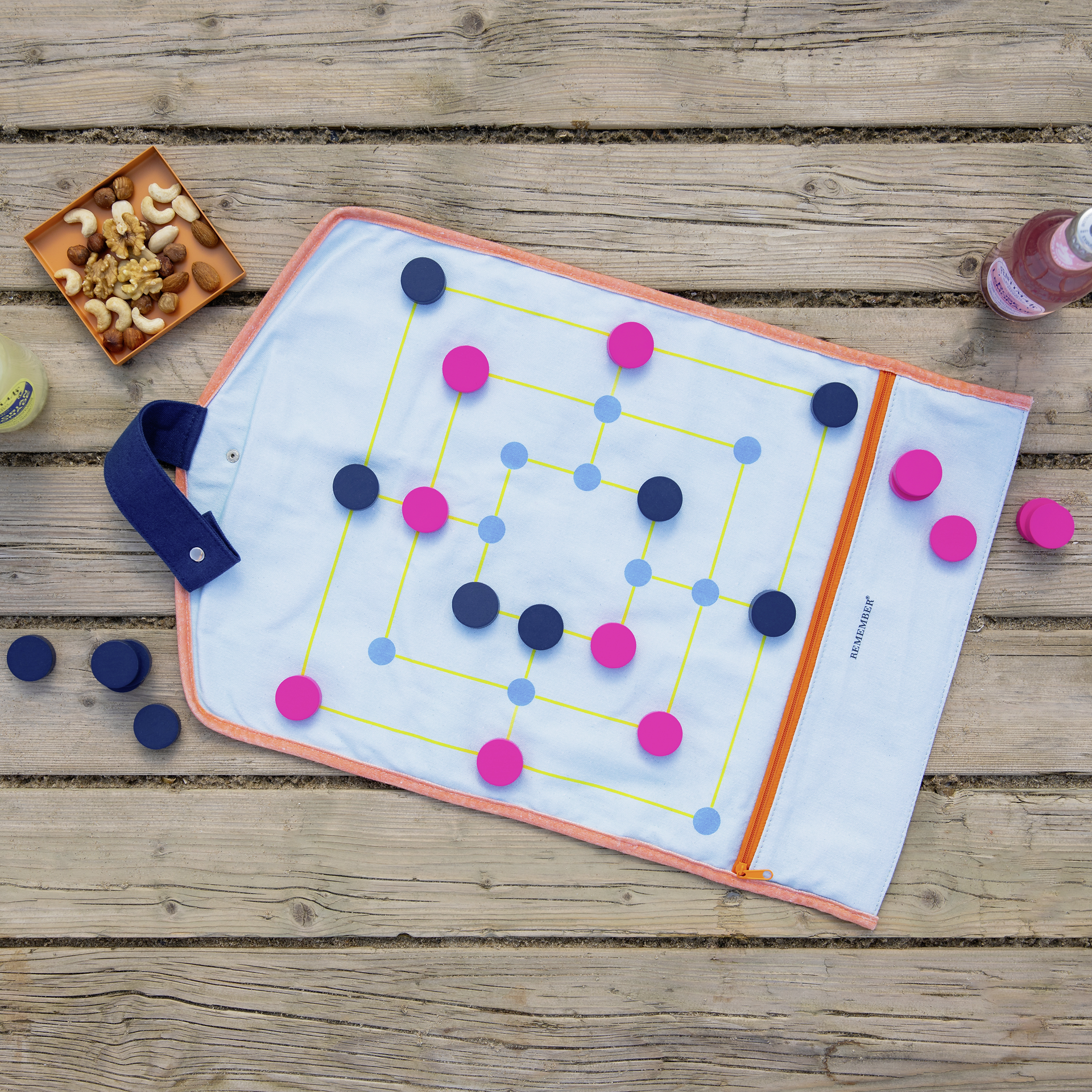 Zwei textile 'Roll-Up' Brettspiele in Blau und Gelb mit Spielsteinen in Pink und Dunkelblau. Sichtbar sind die aufgedruckten Spielfelder und die Aufhänge-Laschen.