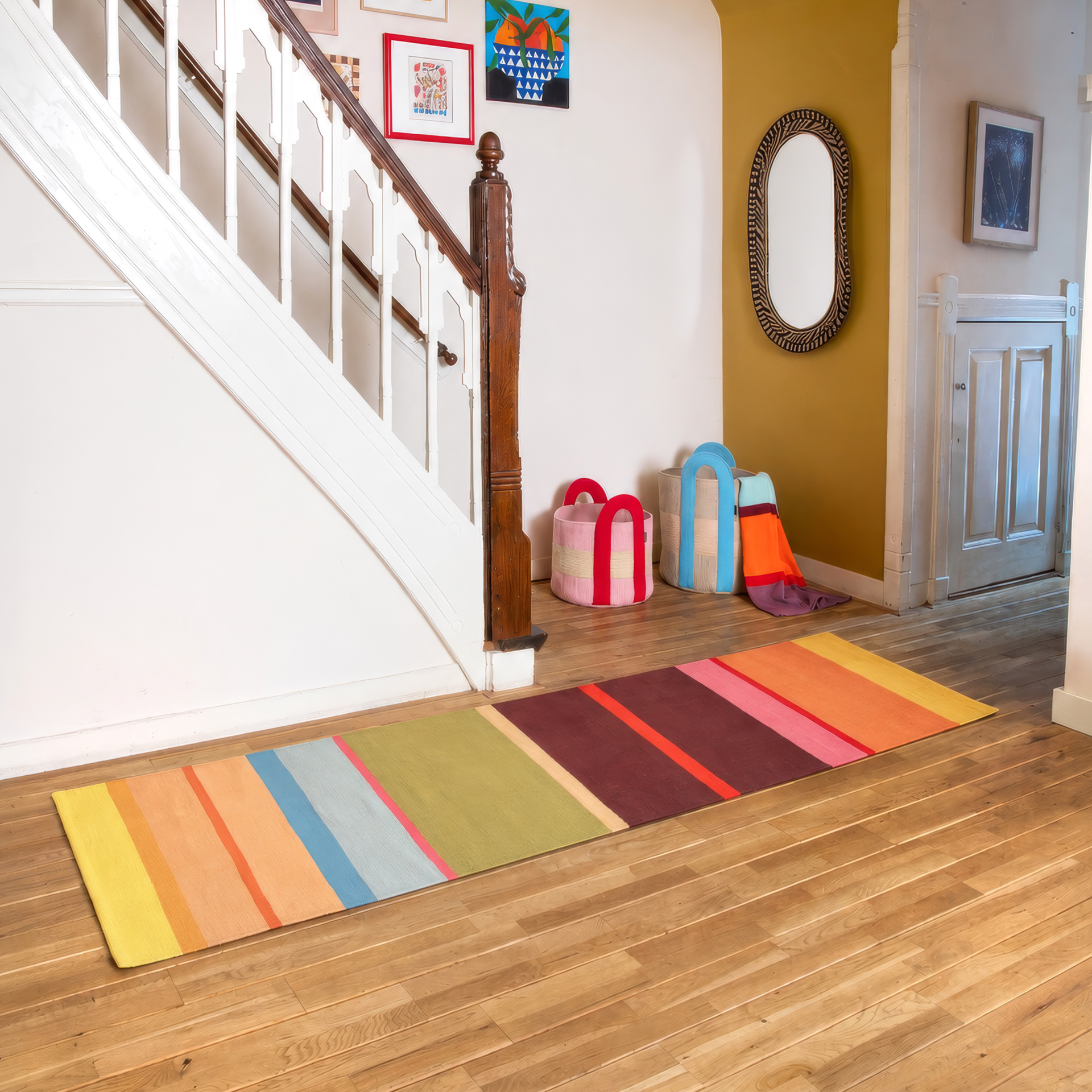 Long tapis de passage tissé à la main en pur coton, avec rayures verticales aux couleurs vives : larges bandes de jaune clair, pêche, bleu ciel, vert olive, marron, rose et orange, et fines touches d'orange, rose et rouge.