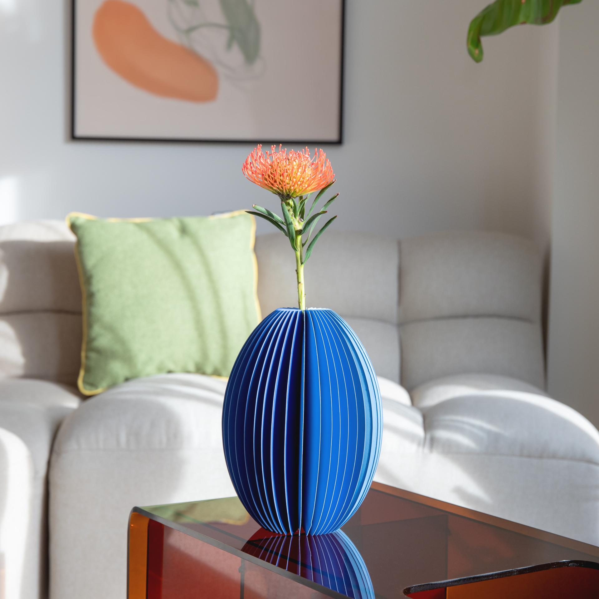 Blaue Papiervase 'Yuki', gefaltet und mit abwechselnd hellen und dunklen blauen Streifen. Runde Form, die oben geöffnet ist.