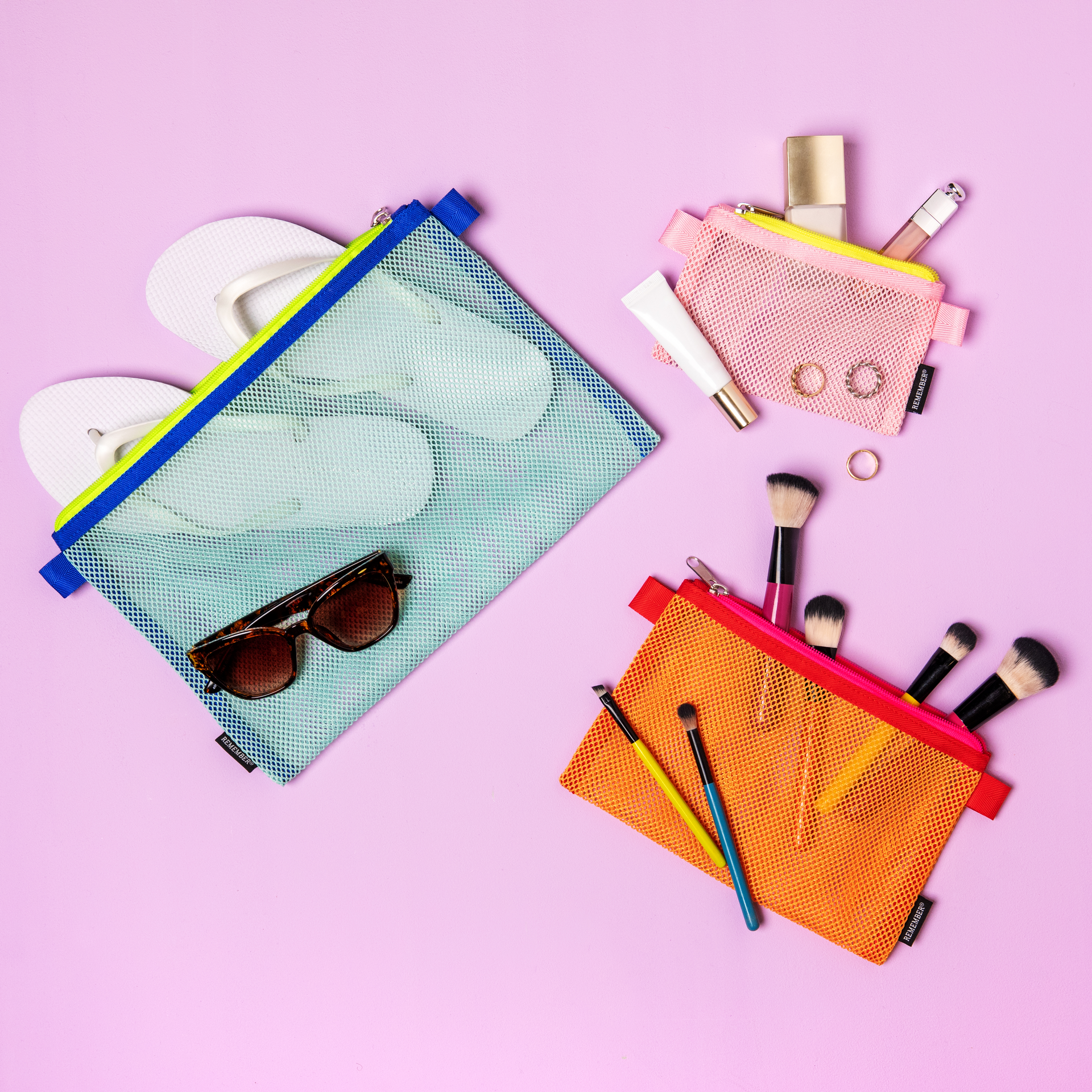 Drei farbige Mesh Bags 'Alice' im Set. Größen: groß, türkis; mittel, orange; klein, rosa. Jede Tasche hat einen Reißverschluss.