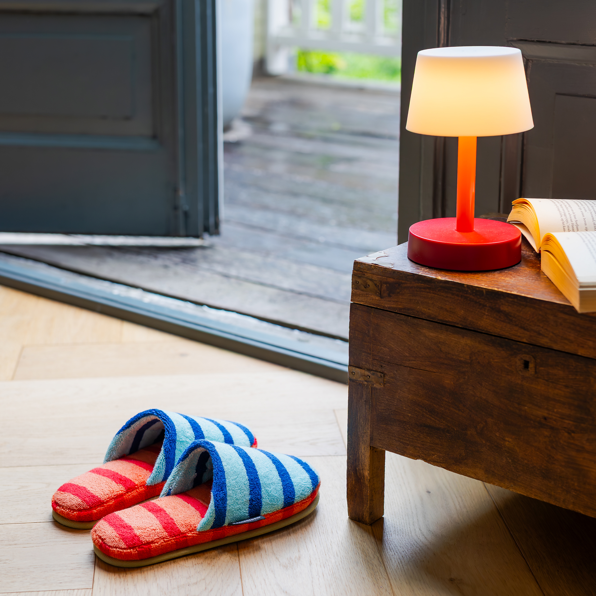 Zwei blaue 'Mello' Slipper mit Streifen und rot-karierten Sohlen.