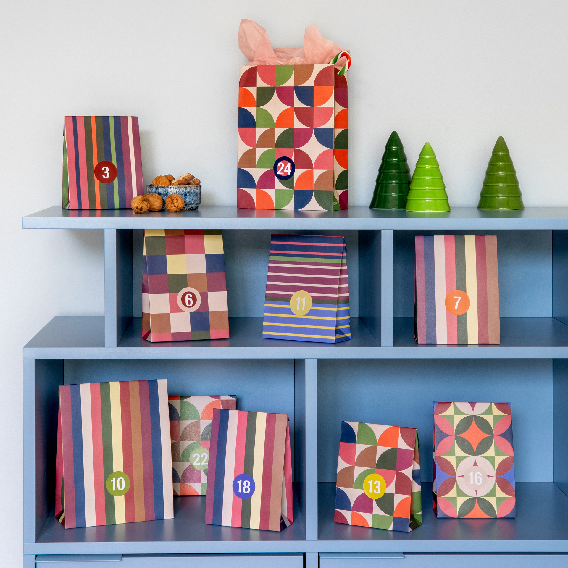 24 sachets colorés pour calendrier de l'Avent, tailles variées, motifs à carreaux, rayures et géométriques. Avec autocollants numérotés 1-24 et autocollants blancs vierges. Idéal pour un calendrier personnalisé.