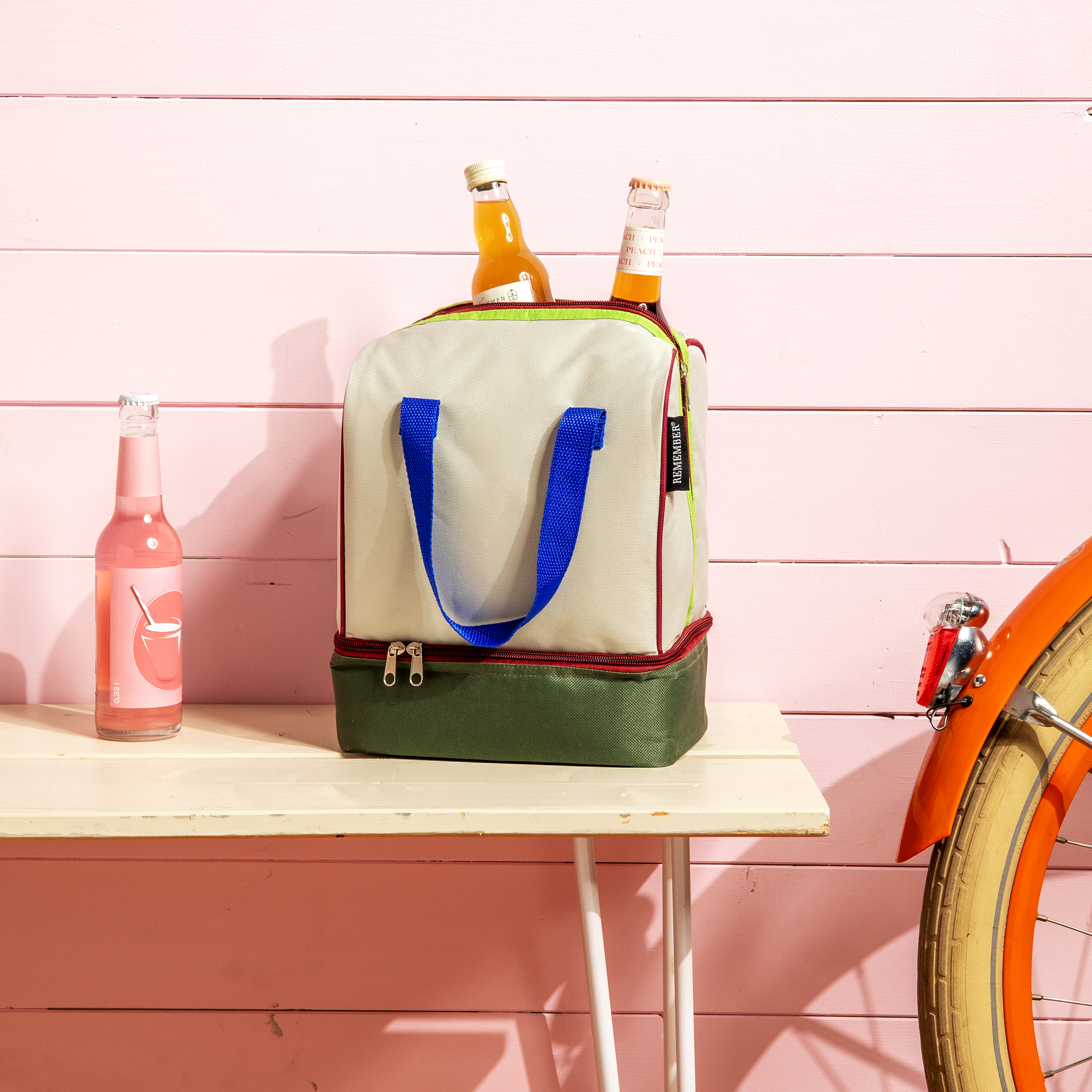 Beige Lunch-Kühltasche 'Bruno' mit zwei Fächern und Reißverschlüssen. Tragegriffe in Blau und farbige Akzente in Grün und Pink.