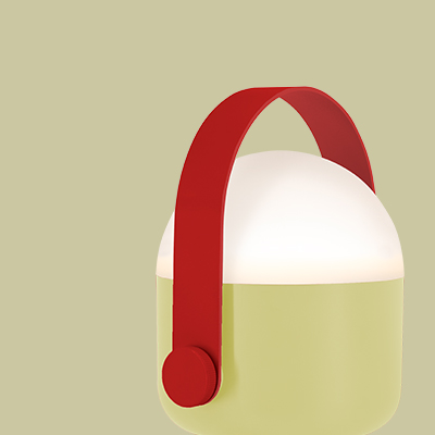 Eine runde Lampe mit einem grünen unteren Teil, einem weißen oberen Teil, der leuchtet, und einem roten Tragegriff.