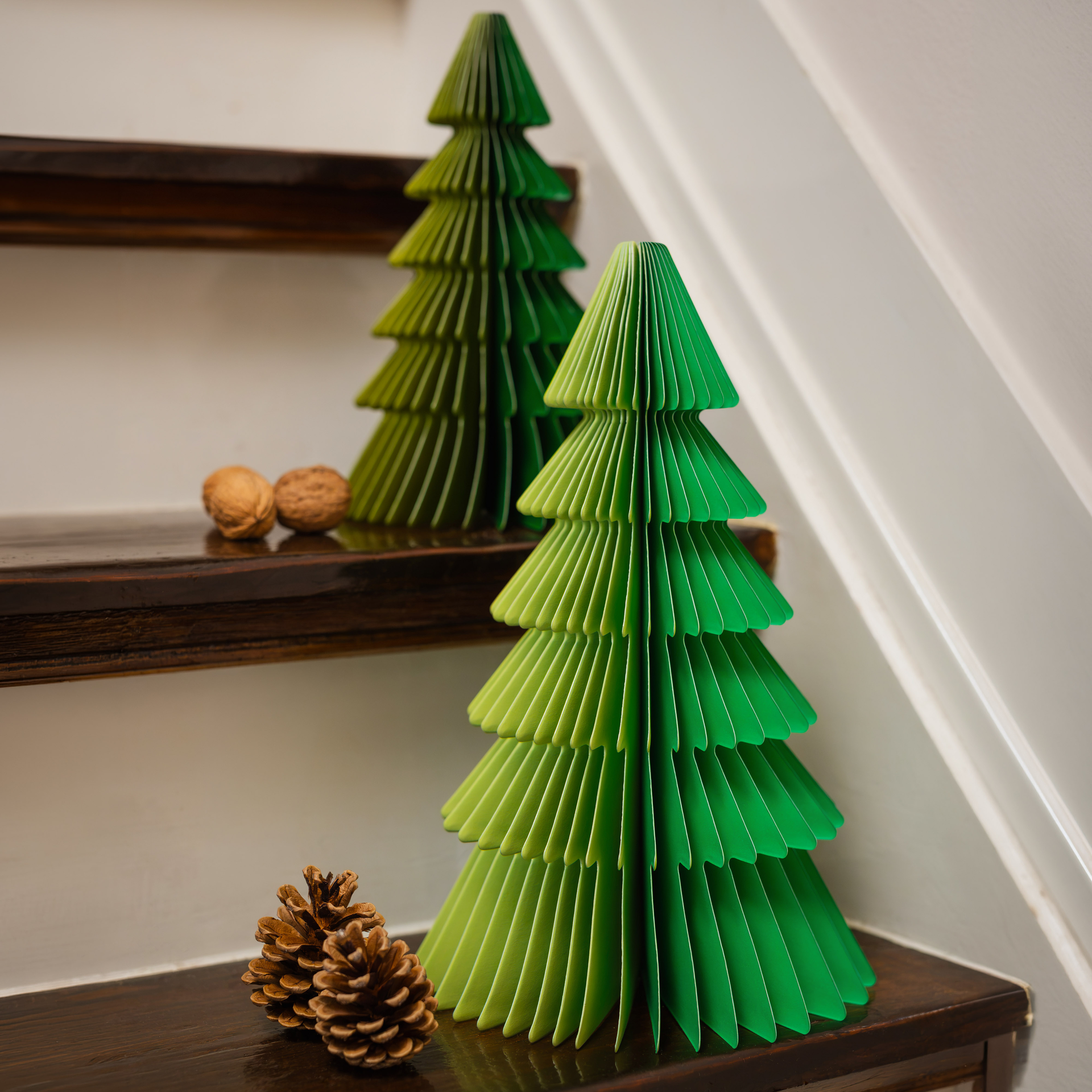 Deux sapins Finn en papier, en deux tailles, réalisés avec soin en papier de haute qualité. Motif bicolore vert clair/vert foncé, sublimé par le pliage en accordéon. Ces sapins festifs apportent une touche d'élégance.
