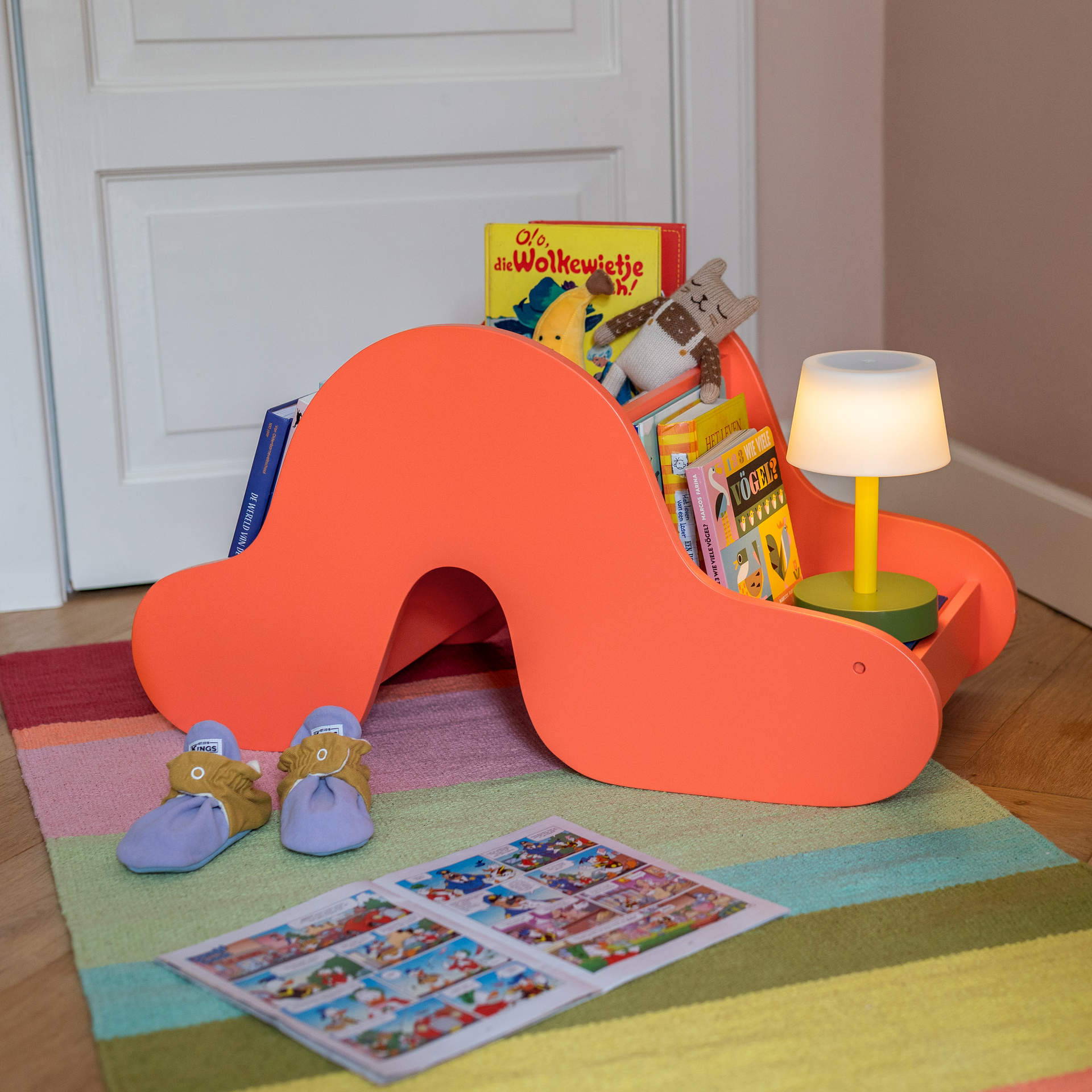 Freistehendes, korallfarbenes Bücherregal „Raupe Frieda“ mit Fächern, gefertigt aus MDF, für das Kinderzimmer.