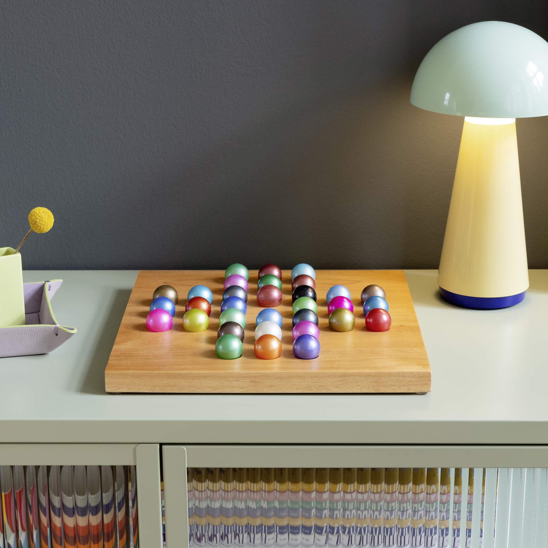 Un jeu de solitaire : Plateau en bois avec 32 billes de verre colorées.