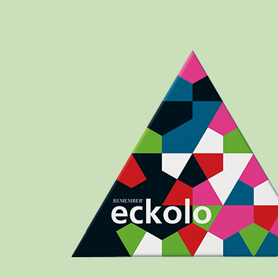 Ein Dreieck, dessen Fläche in unregelmäßige geometrische Formen in Rot, Blau, Grün, Weiß, Pink und Schwarz unterteilt ist, mit dem Schriftzug "eckolo". Der Hintergrund ist einfarbig hellgrün.