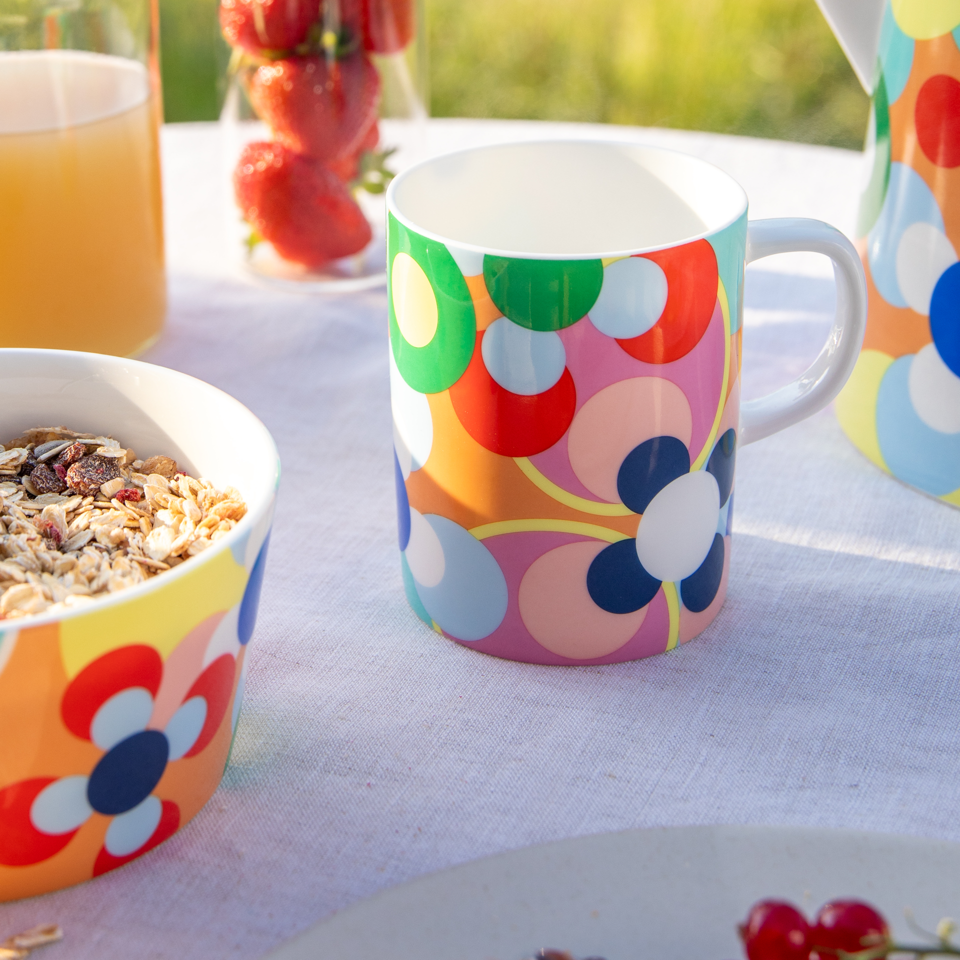 Une tasse en porcelaine avec une anse décorée d'un motif circulaire coloré en jaune, vert, rouge, rose et bleu.