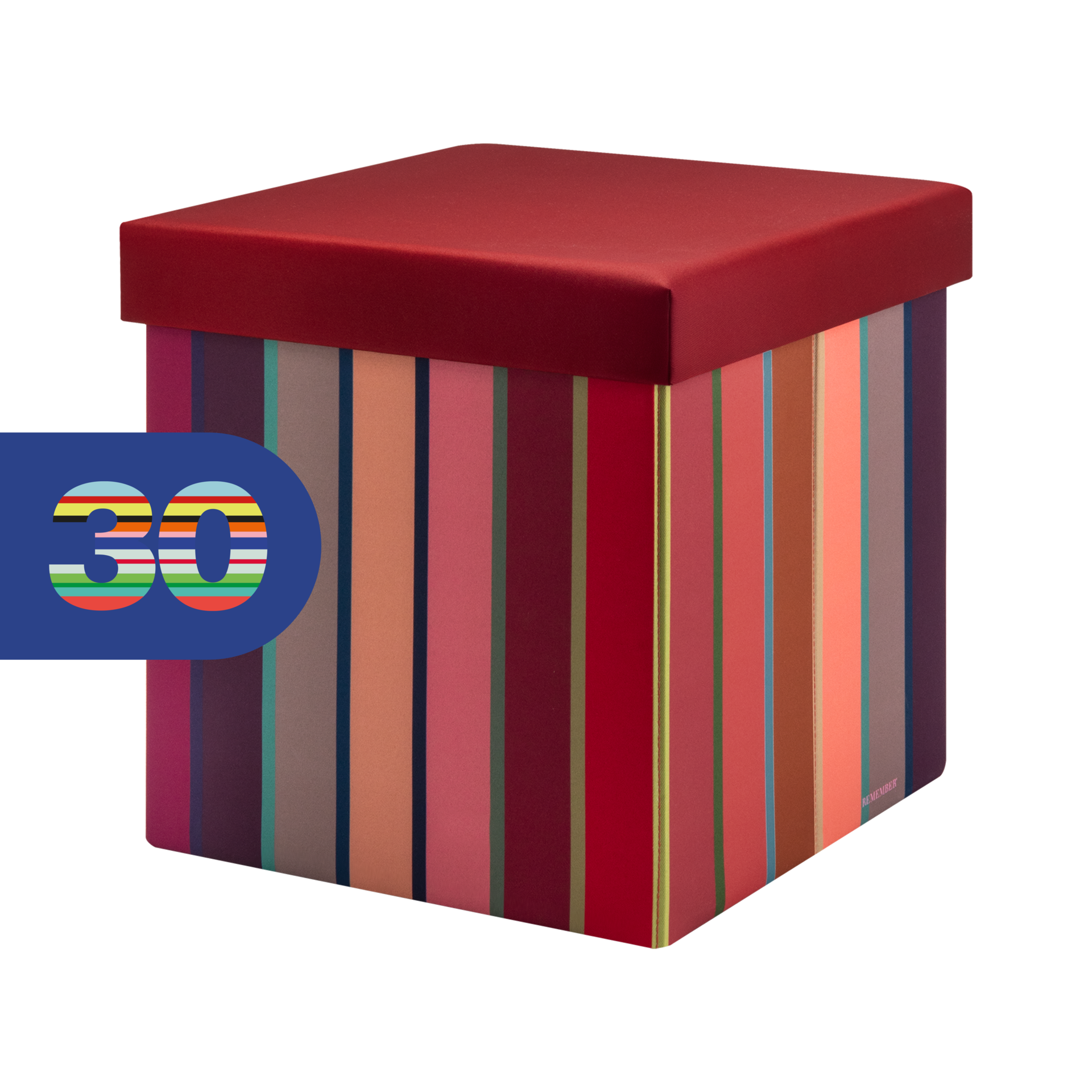 Boîte-siège cubique avec couvercle rembourré rouge foncé. Côtés à motif de rayures verticales vives : rouge, rose, orange, marron, bleu et vert. En haut à gauche, étiquette bleue « Remember 30 » avec « 30 » multicolore.