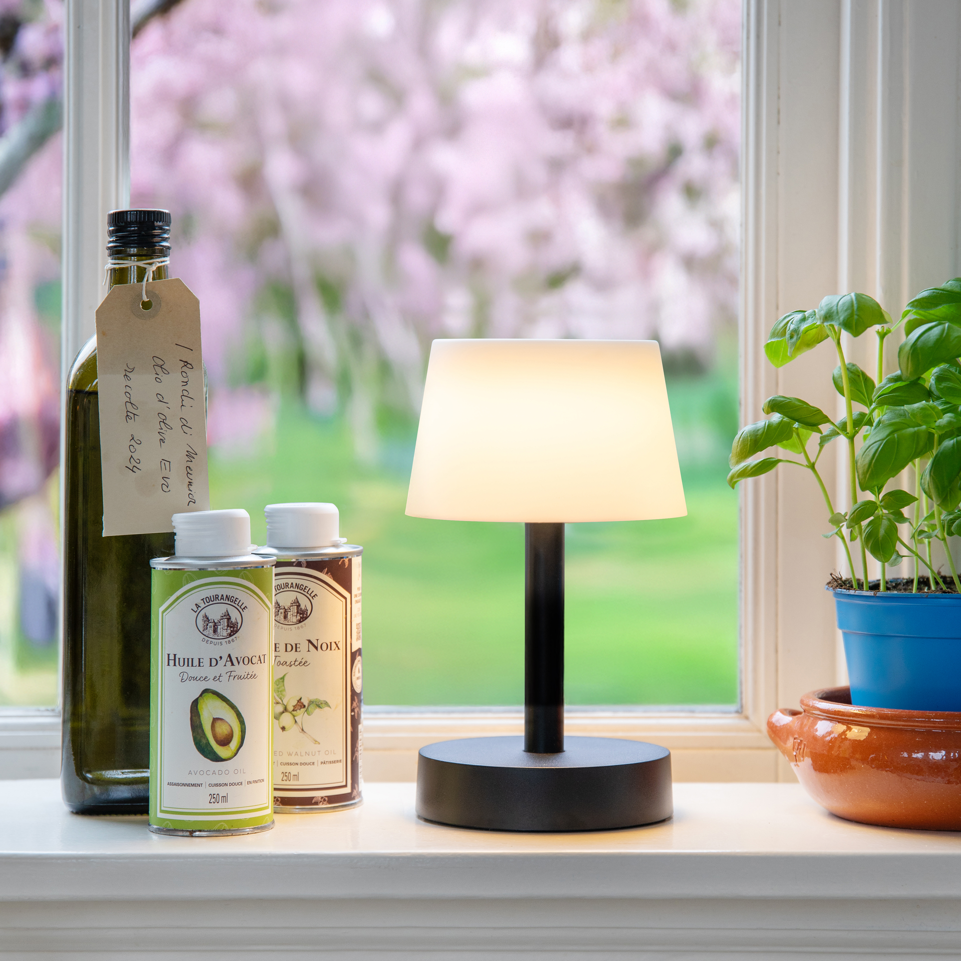 Lampe de table 'Fritz pure', simple et à intensité variable : le pied rond noir se prolonge par une fine tige qui porte un abat-jour conique blanc.