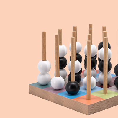 Holzspielzeug mit Stäben, auf denen weiße und schwarze Kugeln aufgereiht sind, auf einem Brett mit farbigen Quadraten.