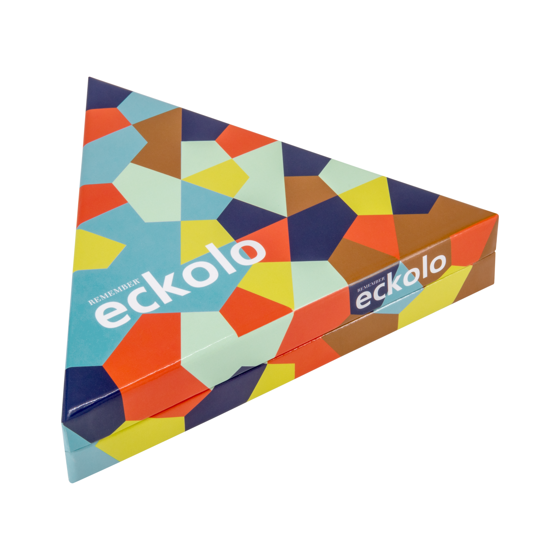 Dreieckige Schachtel des Spiels Eckolo mit buntem geometrischen Muster aus Polygonen in Blau, Orange, Gelb und Braun. Der Schriftzug „eckolo“ ist zweimal sichtbar. Leicht schräg von oben vor weißem Hintergrund.