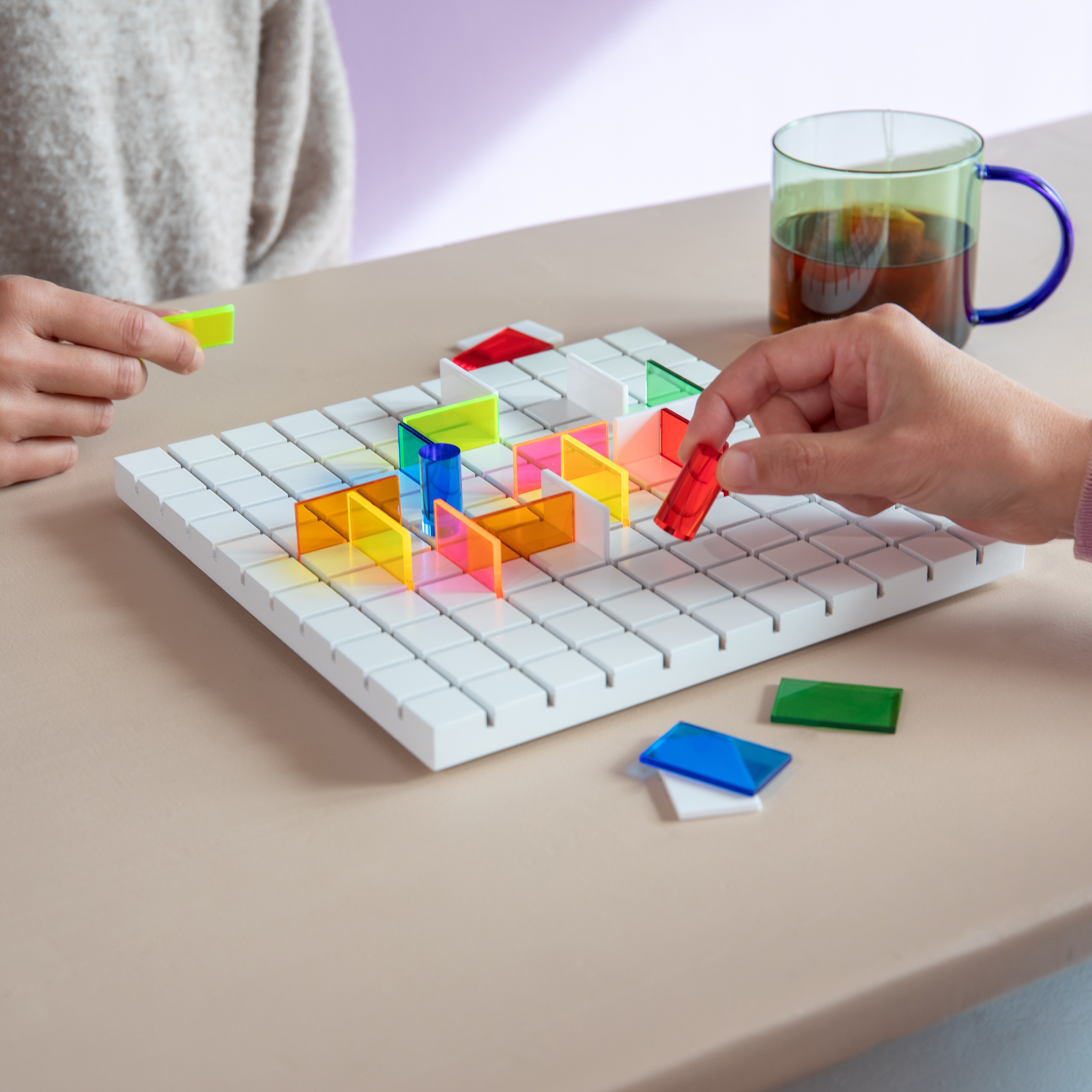 Verpackung von PASO, ein Taktikspiel mit einem weißen Spielbrett mit Spielfiguren und Hindernissen in verschiedenen Farben.