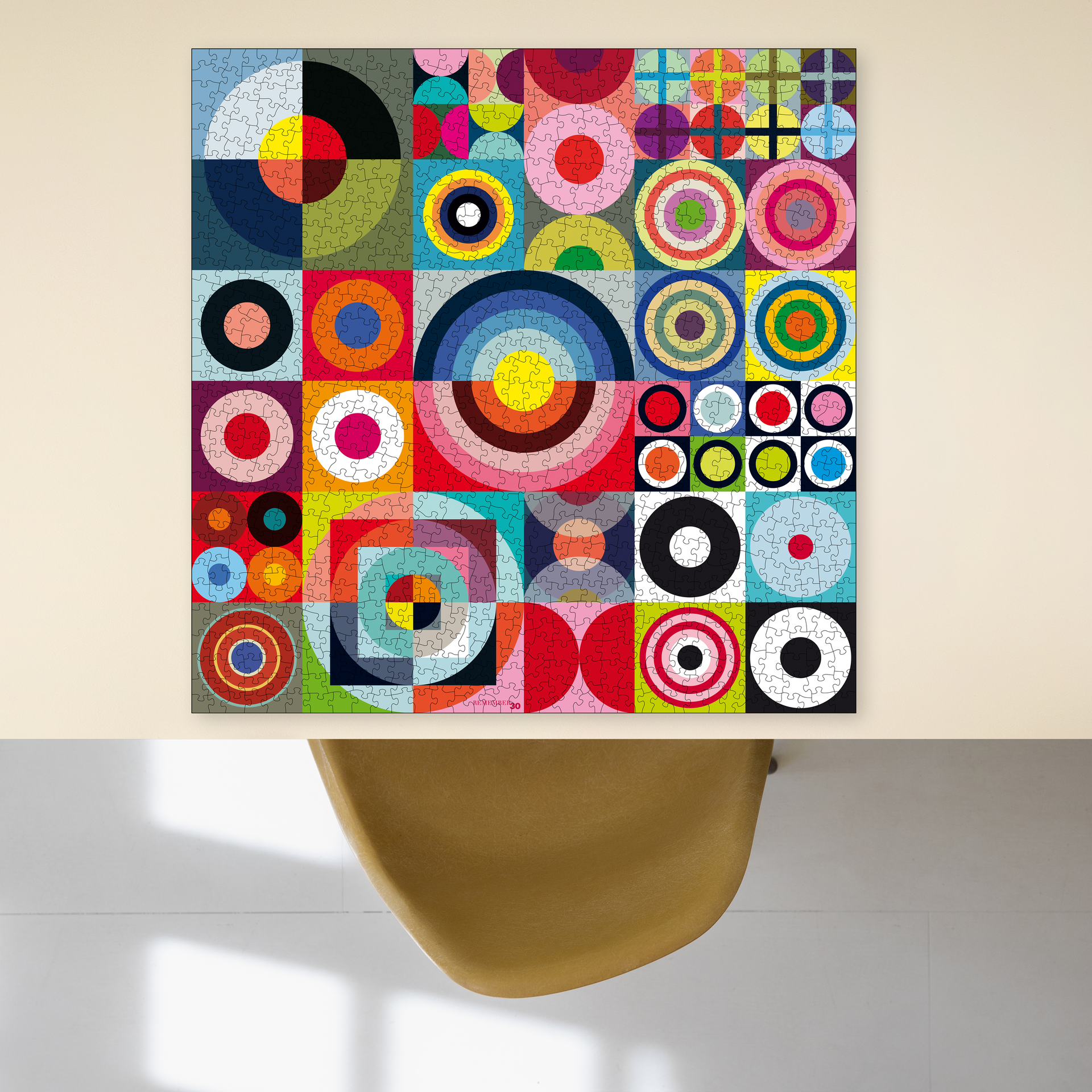Puzzle REMEMBER® 30 de 1 000 pièces terminé : grille abstraite aux couleurs vives composée de cercles et de demi-cercles rouges, bleus, jaunes, verts, roses et noirs. À côté, une boîte blanche portant l'inscription « 1000 PUZZLE ».