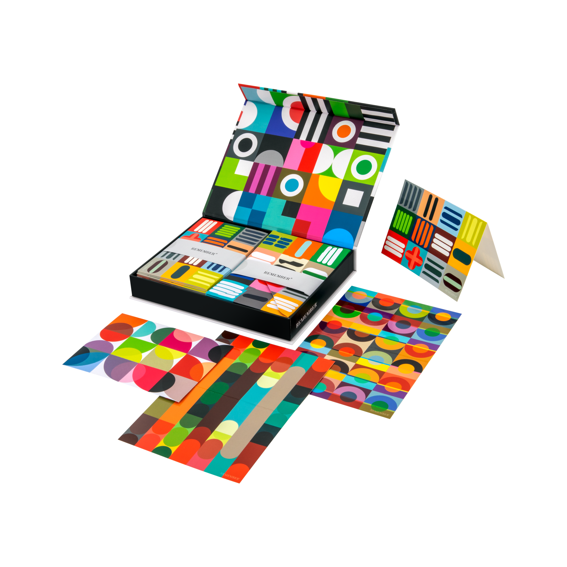 Offenes Kartenset "Remember" mit farbenfrohen, geometrischen Mustern, inklusive Karten, Umschlägen und einer Magnetbox.