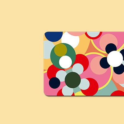 Abstraktes Muster mit bunten Kreisen, die teils Blütenformen ähneln. Farben: Rot, Weiß, Pink, Gelb, Grün, Blau und Olivgrün. Helle, gelbliche Hintergrundfarbe.