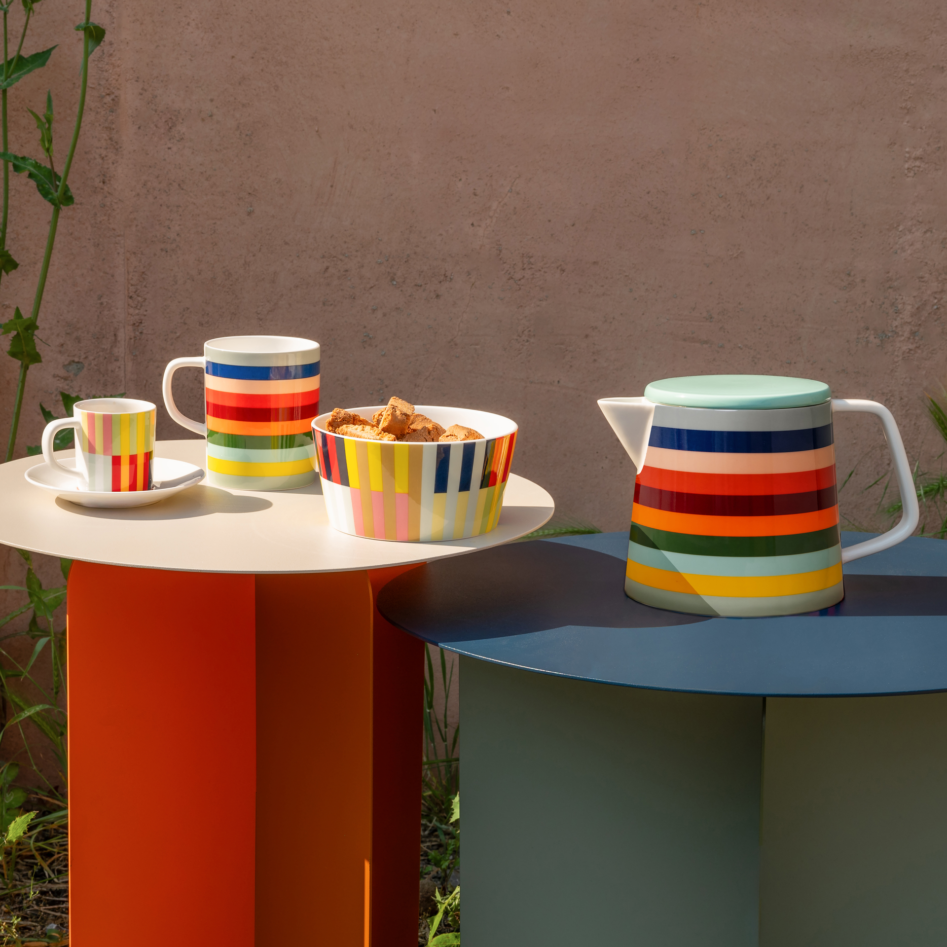 Eine Müslischale aus der 'Havanna' Kollektion mit bunten, vertikalen Streifen in Gelb, Grün, Rosa, Rot, Orange, Schwarz und Türkis vor weißem Hintergrund.