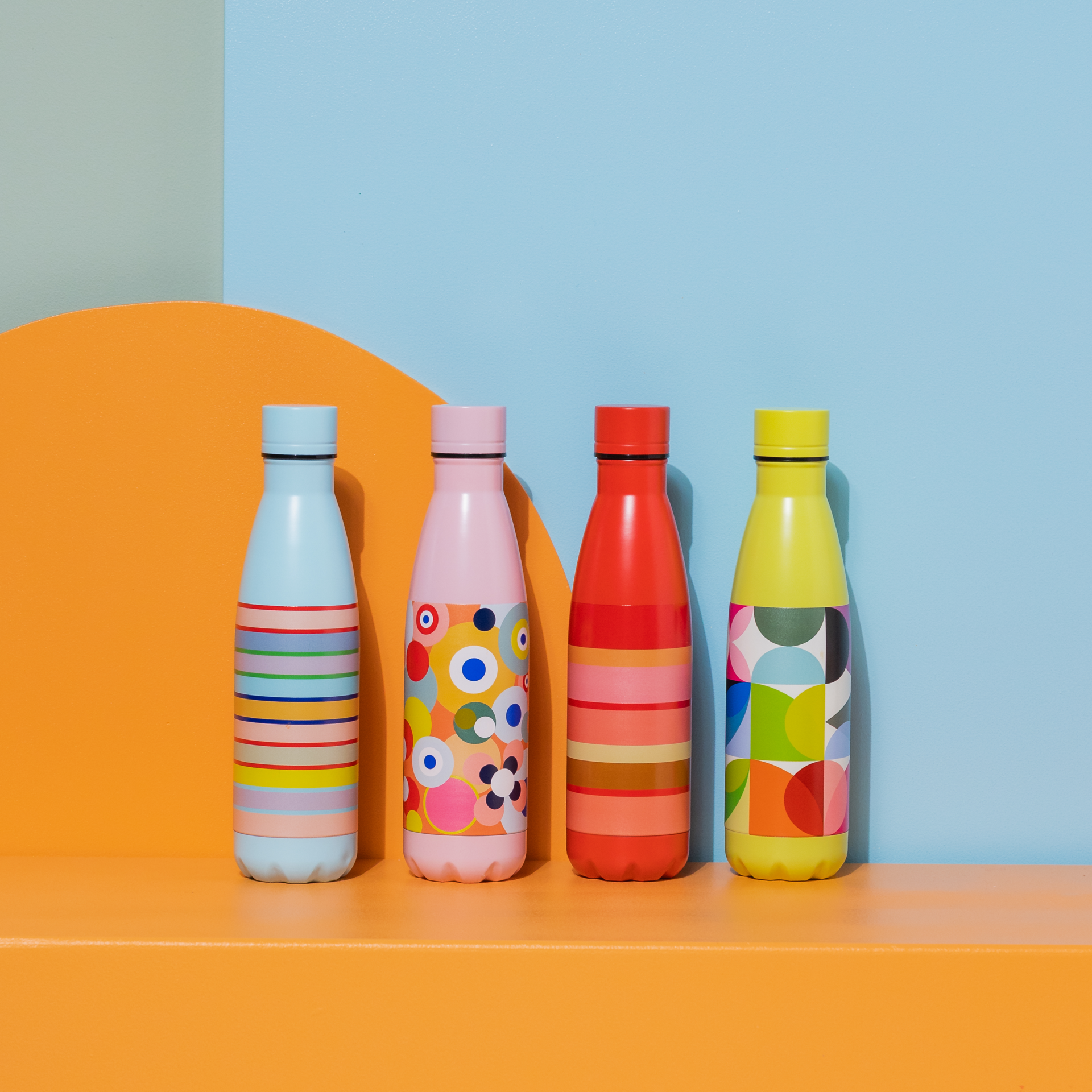 Rosa Edelstahl-Trinkflasche mit buntem Kreismuster und rosa Deckel. Links daneben ein blaues Feld mit einer bunten 30.