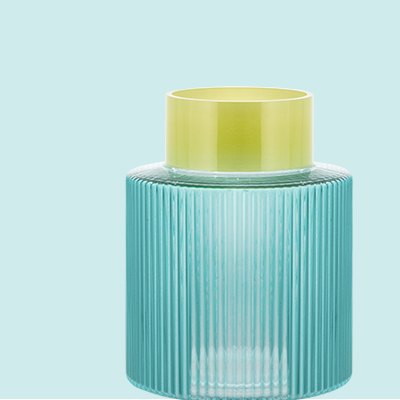 Eine Vase aus geriffeltem, hellblauem Glas mit einem gelben oberen Rand vor einem hellblauen Hintergrund.