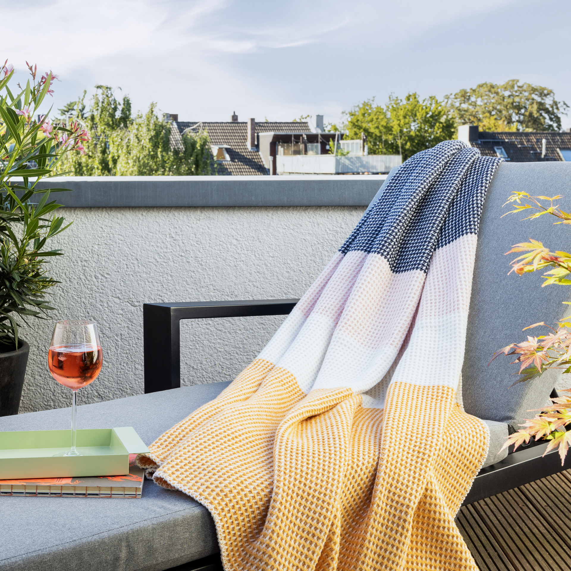 Eine Gala-Decke mit Waffelmuster in den Farben Orange, Weiss, Rosa und Dunkelblau liegt auf einem weissen Hintergrund.