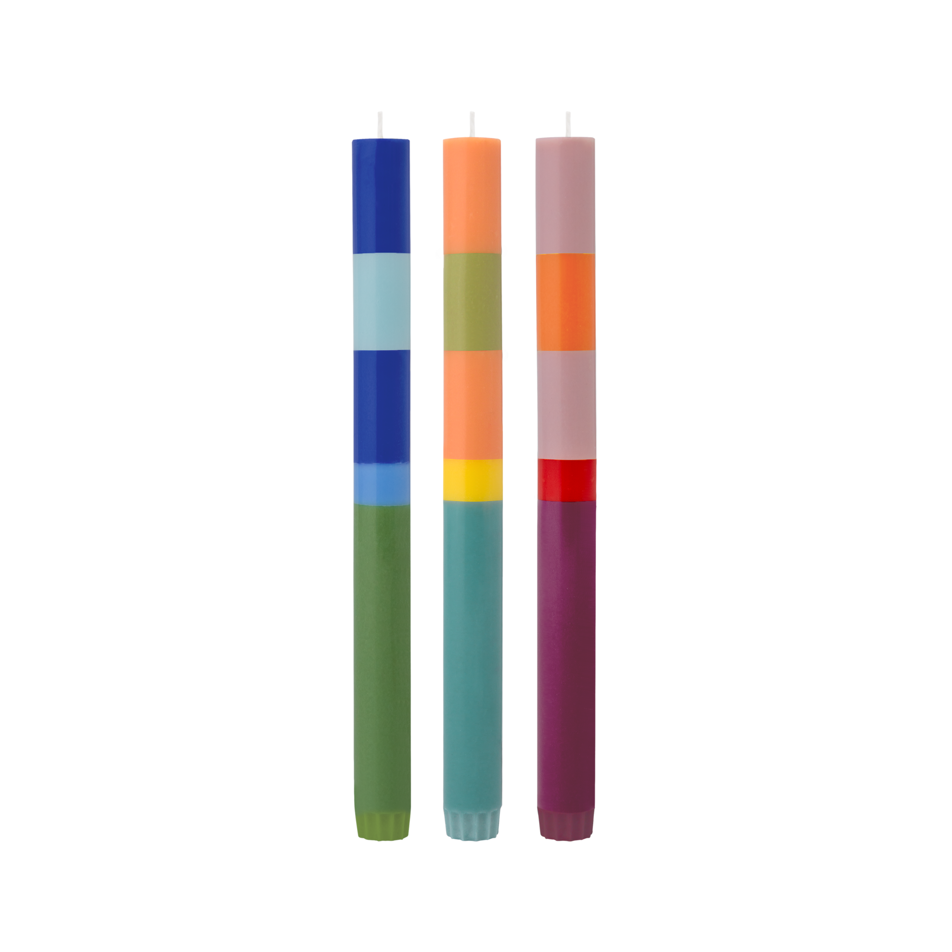 Drei 'Venezia' Stabkerzen im Color-Blocking-Design. Die Kerzen sind blau-grün, orange-grün und lila-rosa gestreift.